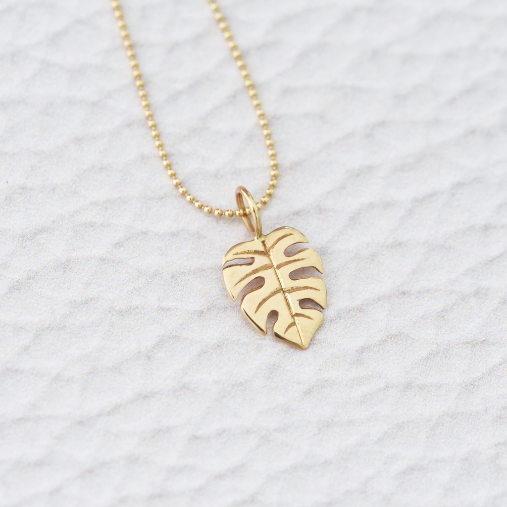 Solid 14k yellow gold monstera charm by Corkie Bolton Jewelry.