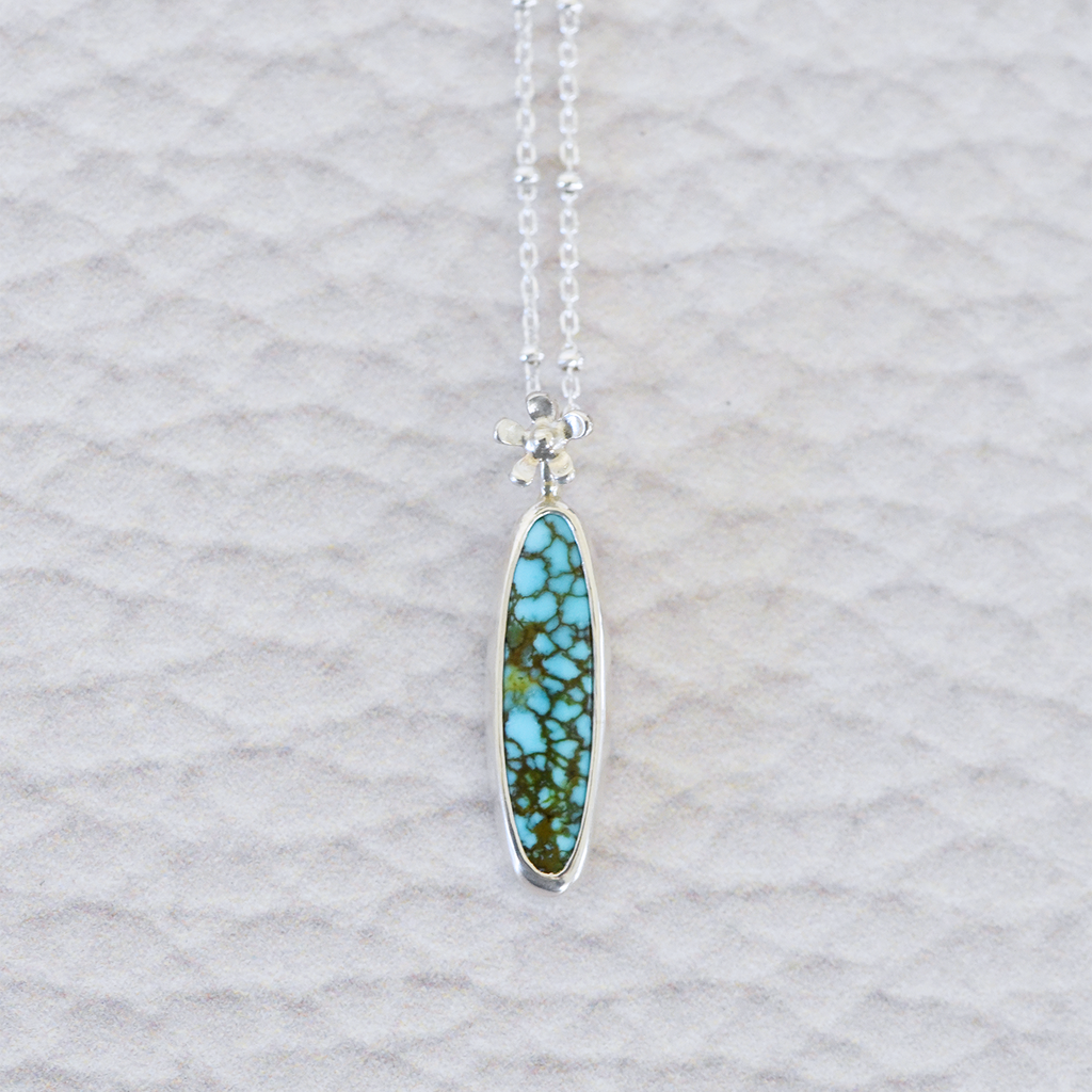 Sterling silver and american turquoise necklace featuring a tiny hand fabricated flower.