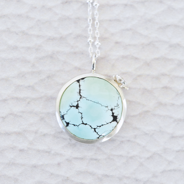Sterling silver and Sand Hill Turquoise necklace featuring a tiny hand fabricated flower.