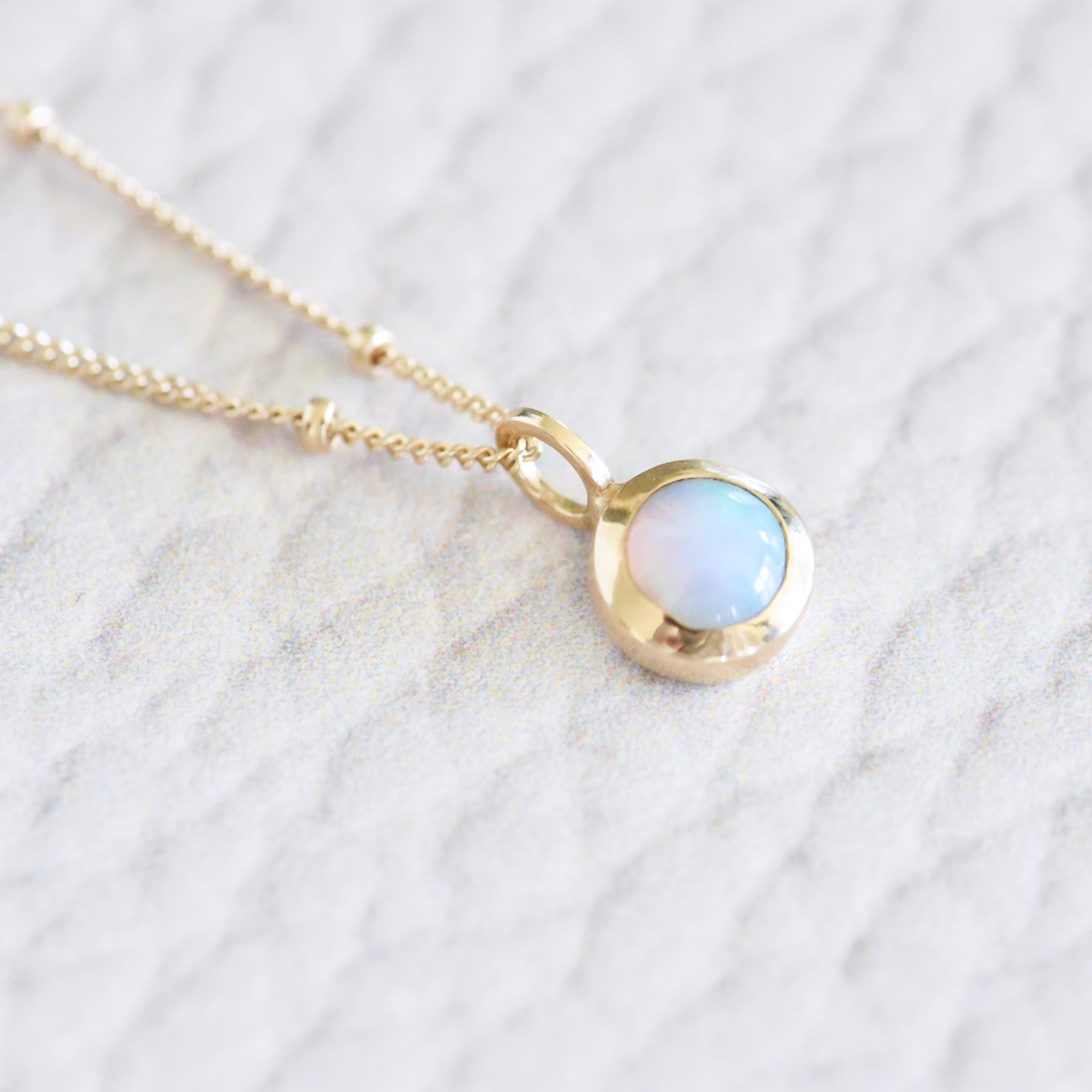 This opal has it all! Flashes of orange, green and blue. Set in 14k yellow gold, it's a perfect everyday kind of piece and hangs on an extra long 24" beaded 14k yellow gold chain.